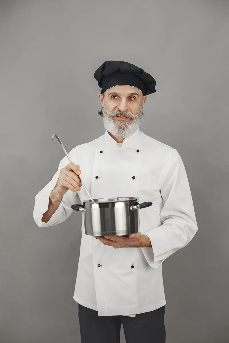 Chef in a white double-breasted jacket holding a pot and ladle